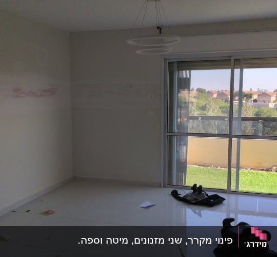 חדר ריק עם חלון גדול וכלים על הרצפה